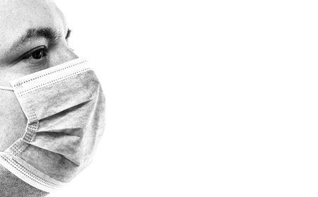 Detail BW photo of sick young man with medical protective face mask illustrates Covid 19 disease...