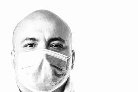 Detail BW photo of sick young man with medical protective face mask illustrates Covid 19 disease isolated on white. Covid-19 outbreak, flu contamination and healthcare conceptの写真素材