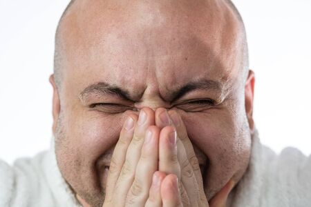 Caucasian sick young man sneezing due to Covid 19 disease isolated on white. Covid-19 outbreak, flu contamination and healthcare conceptの写真素材