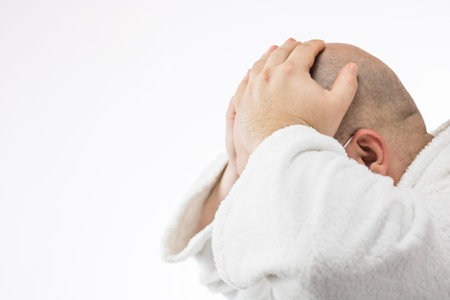 Caucasian sick young man with pain and medical protective face mask illustrates Covid 19 disease isolated on white. Covid-19 outbreak, flu contamination and healthcare conceptの写真素材
