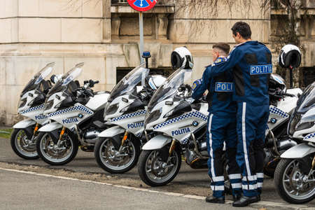 Police agent on motorcycle, Romanian Police (Politia Rutiera) car patrolling streets to avoid curfew breaches amid the spread of the COVID-19 in downtown Bucharest, Romania, 2020のeditorial素材