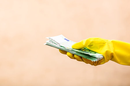 World money concept, hand with gloves receiving, giving or holding 100 EURO banknote, isolated on blurred background. Corona virus COVID-19 outbreak. Concept of prevention virus spreadの写真素材