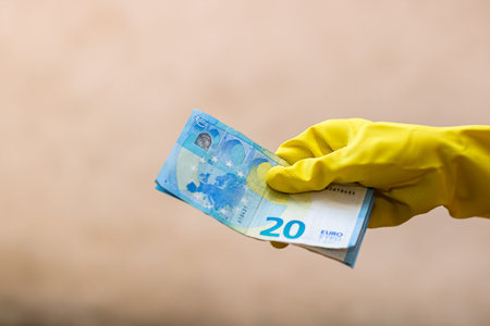 World money concept, hand with gloves receiving, giving or holding 20 EURO banknote, isolated on...