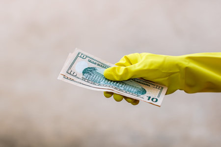 World money concept, hand with gloves receiving, giving or holding 10 USD banknote, isolated on...