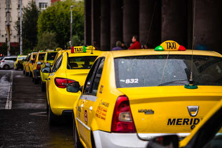 Car in traffic, modern city taxi service. Taxi cars parked at the taxi station in the capital city of Bucharest, Romania, 2020のeditorial素材