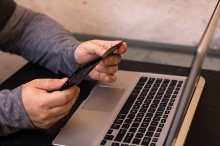 Hands holding credit card and using smartphone and laptop. Online shopping, on line payment conceptの写真素材