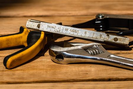Tools for repair and building. Hummer, adjustable spanner, ruler. Instruments on rustic wooden table...