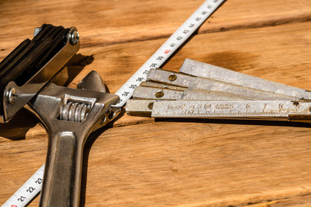 Tools for repair and building. Hummer, adjustable spanner, ruler. Instruments on rustic wooden table...