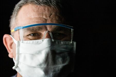 Man with protective medical mask and protective goggles. Coronavirus Covid-19 outbreak, flu contamination and healthcare conceptの写真素材