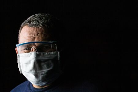 Man with protective medical mask and protective goggles. Coronavirus Covid-19 outbreak, flu contamination and healthcare conceptの写真素材