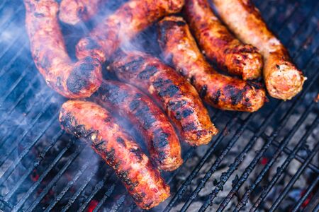 Sausages grilled on a charcoal barbeque. Top view of tasty barbecue, food concept, food on grill and detail of sausages on the grillの写真素材