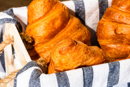 Fresh croissant, puff pastry and buttered french croissant on wooden crate. Food and breakfast...