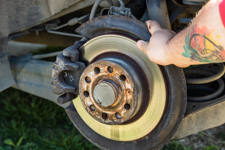 Automotive mechanic checking brake system. Vehicle maintenance in the garage in Bucharest, Romania,...