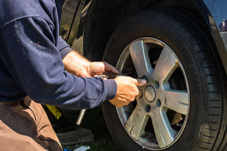 Car mechanic screwing or unscrewing car wheel by wrench at car garage in Bucharest, Romania, 2020のeditorial素材