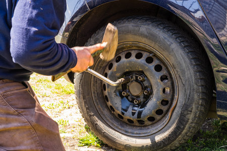 Car mechanic screwing or unscrewing car wheel by wrench at car garage in Bucharest, Romania, 2020