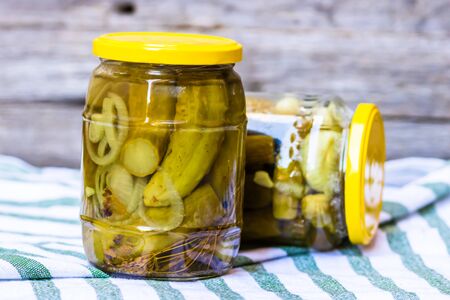Glass jar with pickles isolated. Preserved food concept, canned vegetables isolated in a rustic composition.の写真素材