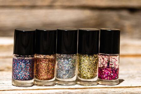 Colorful, bright and glittery nail polish bottles isolated with copy space. Close up of bottles with colorful nail polish.の写真素材