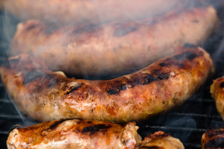 Close up on details of homemade sausages on barbecue grill. Barbecue, grill and food concept.の写真素材