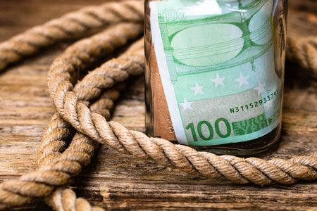 Composition with saving money banknotes in a glass jar. Concept of investing and keeping money, close up isolated.の写真素材