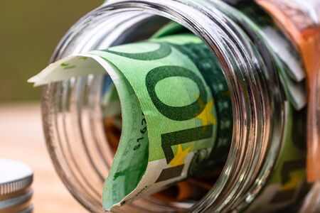 Composition with saving money banknotes in a glass jar. Concept of investing and keeping money, close up isolated.の写真素材