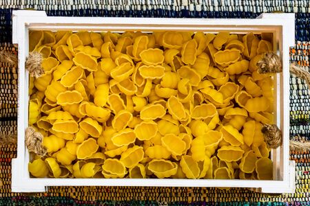 Gnocchi, raw italian pasta in wooden crate in a rustic composition.の写真素材