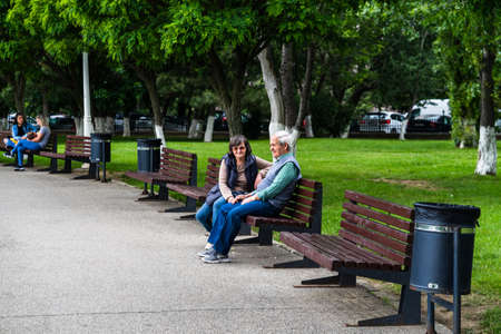 People old couple standing on benches, relaxing and have fun in park, freshly mowed grass.  Bucharest, Romania, 2020のeditorial素材