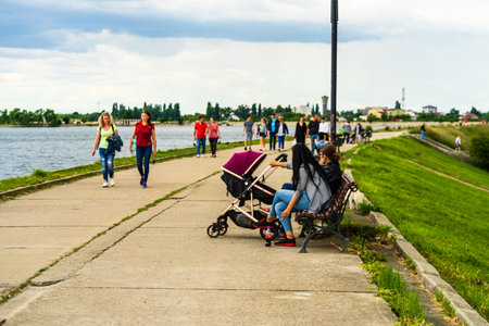 People walking, relaxing and have fun on the alleys of a park near a lake. Bucharest, Romania, 2020のeditorial素材