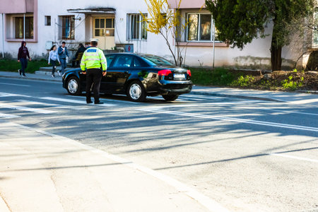 Police officer directing traffic in downtown junction in Targoviste city. Targoviste, Romania, 2020のeditorial素材