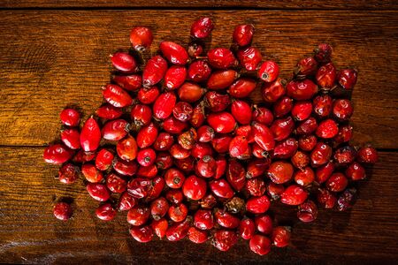 Fresh red rosehips on wooden close up isolatedの写真素材