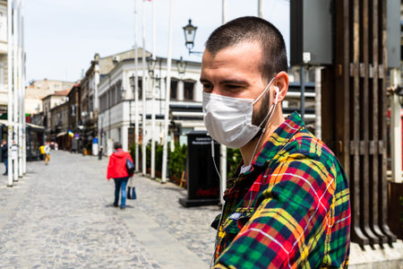 Funky hipster young man wearing medical mask in Bucharest, Romania, 2020
