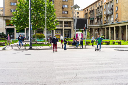 Pedestrians waiting to cross the street in Bucharest, Romania, 2020