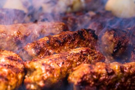 Traditional Romanian food Meat Balls "mici" on grill. Tasty meat balls on barbeque, pork meat on charcoal barbecueの写真素材