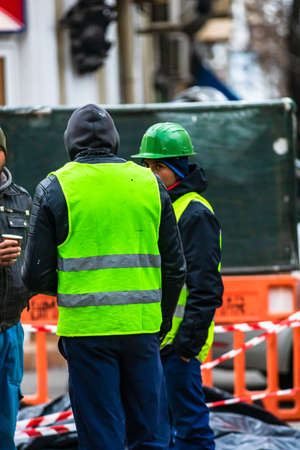 Contruction workers wearing reflective vest preparing for work for repairing street curbs. Bucharest, Romania, 2020のeditorial素材