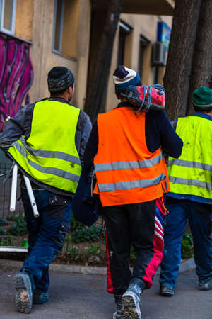 Back view of construction workers wearing reflective vest preparing for work. Bucharest, Romania, 2020のeditorial素材
