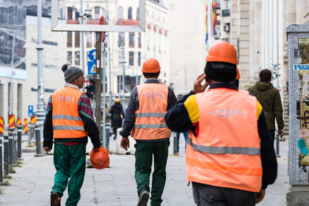 Contruction workers wearing reflective vest preparing for work for repairing street curbs. Bucharest, Romania, 2020のeditorial素材