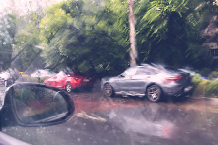 Traffic in rainy day with road view through car window with rain drops, blurry traffic on rainy day....