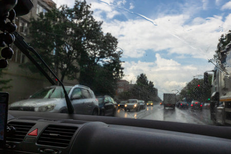 Traffic in rainy day with road view through car window with rain drops, blurry traffic on rainy day....