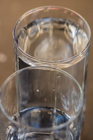Detail photo of water glass on blurred background. Water poured into a clear glass