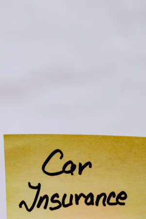 Car insurance handwriting text close up isolated on yellow paper with copy space.の写真素材