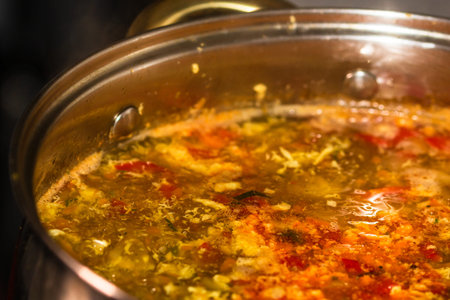 Preparation of soup with chicken and vegetables. Close up of boiling soup.