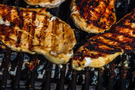 Chicken and pork steak grilled on a charcoal barbeque. Top view of camping tasty barbecue, food concept, food on grill and detail of food on the grillの写真素材