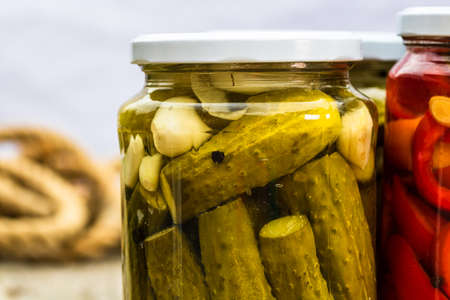 Close up of glass jar with pickles isolated. Preserved food concept, canned vegetables isolated in a rustic composition.の写真素材