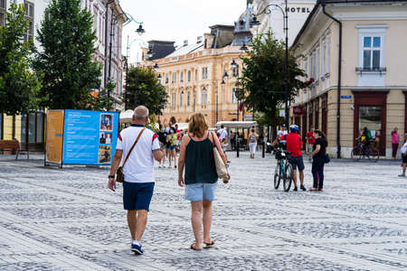 People wandering and having lunch at local restaurants on the streets of Sibiu old town during coronavirus crisis. Sibiu, Romania, 2020.のeditorial素材