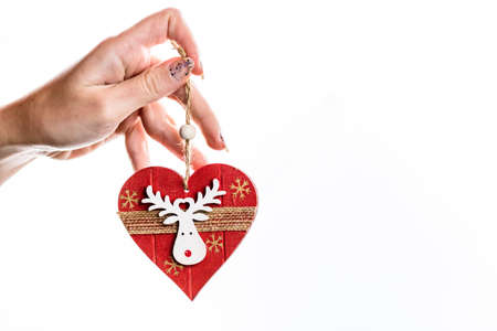 Hand holding heart shaped Christmas decoration isolated on white.の写真素材