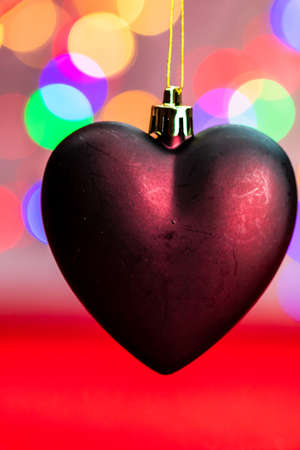 Heart shaped Christmas decoration isolated on blurred background of lights.の写真素材