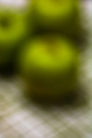Out of focus, green apples on rustic table napkin.の写真素材