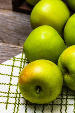 Detail on ripe green apples on wooden table.の写真素材