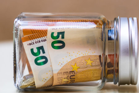 Composition with saving money banknotes in a glass jar. Concept of investing and keeping money,...