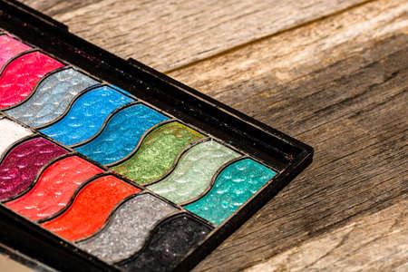 Make up eyeshadow palette close up isolated on wooden background with copy space.の写真素材