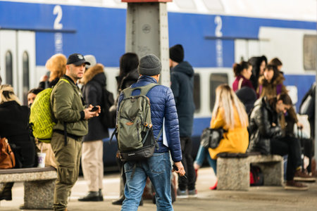 Travelers and commuters carry luggage and backpacks on the train platform of Bucharest North Railway...